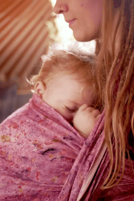 sleeping baby in a babywearing sling made of hemp