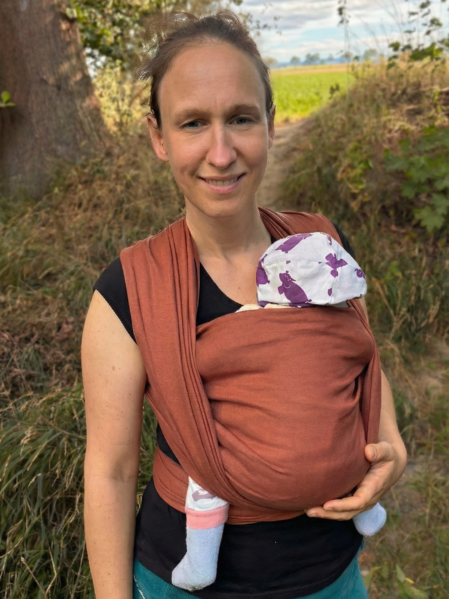 Un bambino che dorme felicemente in una fascia che dorme